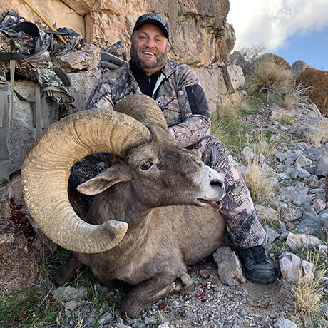 Hunter in camo with a ram